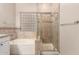 Bathroom with a shower behind glass doors, and a tub with tiled walls and clear glass block window at 4565 N Point Ridge Rd, Buckeye, AZ 85396