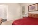 Cozy bedroom showcasing a red comforter, bedside table, and a naturally lit window at 4565 N Point Ridge Rd, Buckeye, AZ 85396