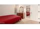 Bedroom featuring a red comforter, dresser, and doorway reflecting into another bedroom at 4565 N Point Ridge Rd, Buckeye, AZ 85396