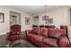 Cozy living room with a red leather sofa, chair, and unique cage-style light fixture at 4565 N Point Ridge Rd, Buckeye, AZ 85396