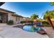 Beautiful backyard pool area featuring a rock waterfall, lush greenery, and desert landscaping at 4565 N Point Ridge Rd, Buckeye, AZ 85396