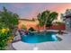 Resort-style pool area features waterfall, lush landscaping, and inviting atmosphere at 4565 N Point Ridge Rd, Buckeye, AZ 85396