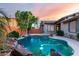 Captivating pool and patio area with rock waterfall feature, landscaped yard and home exterior at 4565 N Point Ridge Rd, Buckeye, AZ 85396