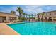 Resort-style pool with palm trees, lounge chairs, and a nearby splashpad at 4565 N Point Ridge Rd, Buckeye, AZ 85396