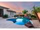 Inviting pool features unique design and rock waterfall, surrounded by lush landscaping at 4565 N Point Ridge Rd, Buckeye, AZ 85396