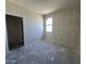 A well-lit bedroom featuring a window and doorway offers potential and a blank canvas for personalization at 47214 W Cansados Rd, Maricopa, AZ 85139