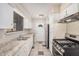 Open kitchen featuring tile backsplash, stainless steel range, and a white entry door at 5738 W Heatherbrae Dr, Phoenix, AZ 85031