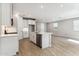 Modern kitchen with stainless steel appliances, white cabinets, center island with seating and wood-look tile flooring at 5840 E Covey Ln, Phoenix, AZ 85054