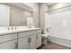Bright bathroom featuring a double sink vanity with white countertop and cabinets, and a shower-tub combo with tiled floor at 5844 E Covey Ln, Phoenix, AZ 85054