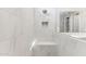 White tiled shower with bench and shampoo nook in primary bathroom at 5844 E Covey Ln, Phoenix, AZ 85054