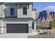 Modern two-story home with a gray garage door, stone accents, and mountain views at 5844 E Covey Ln, Phoenix, AZ 85054