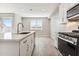 Well-lit kitchen with white cabinetry, stainless appliances, island with sink, open to living area at 5844 E Covey Ln, Phoenix, AZ 85054