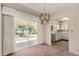 Dining room with sliding glass door, modern chandelier, and adjacent kitchen featuring white appliances at 6027 E Ellis St, Mesa, AZ 85204