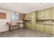 Garage with a wooden workbench, green cabinets for storage, and a concrete floor at 6027 E Ellis St, Mesa, AZ 85204
