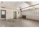 Spacious garage featuring a concrete floor, white brick walls, and a garage door opener at 6027 E Ellis St, Mesa, AZ 85204