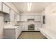 Retro kitchen with bright lighting, ample counter space, white cabinetry, and original appliances at 6027 E Ellis St, Mesa, AZ 85204