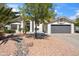 Charming single-story home boasting desert landscaping, a lush tree, and a gray garage door at 6164 E Greenway Ln, Scottsdale, AZ 85254
