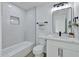 Bathroom boasts a shower-tub combo, modern vanity, and neutral color scheme at 639 N 102Nd Pl, Mesa, AZ 85207