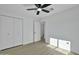 Bright bedroom featuring wood-look floors, ceiling fan, and closet with modern doors at 639 N 102Nd Pl, Mesa, AZ 85207