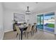 Bright dining room features a modern chandelier, table with seating, and a sliding glass door to the yard at 639 N 102Nd Pl, Mesa, AZ 85207