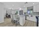 Bright kitchen features white cabinetry, stainless appliances, center island, bar stool seating, and backyard view at 639 N 102Nd Pl, Mesa, AZ 85207