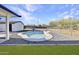 Kidney-shaped swimming pool is surrounded by gravel, turf and brick at 639 N 102Nd Pl, Mesa, AZ 85207