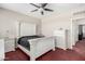 Well-lit bedroom featuring a ceiling fan, carpeted floors, and a comfortable-looking bed at 6505 S 15Th Dr, Phoenix, AZ 85041