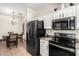 A well-equipped kitchen and dining area with modern appliances, white cabinets, and a stylish chandelier at 6505 S 15Th Dr, Phoenix, AZ 85041