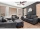 Comfortable living room featuring a ceiling fan, tile flooring, and comfortable seating at 6505 S 15Th Dr, Phoenix, AZ 85041