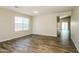 Spacious living room featuring wood-look flooring, neutral walls, and large windows for natural light at 6875 W Townley Ave, Peoria, AZ 85345