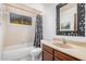 The bathroom showcases a framed mirror, marble countertop, shower with celestial curtain, and soft lighting at 916 W Loughlin Dr, Chandler, AZ 85225