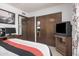 Cozy bedroom features closet, tv, computer and a red, white and black striped comforter at 916 W Loughlin Dr, Chandler, AZ 85225