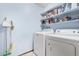 Bright laundry room features a white washer, a white dryer and shelving at 916 W Loughlin Dr, Chandler, AZ 85225