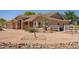 Single-story home featuring desert landscaping, white perimeter fencing, and a tan-colored exterior with stone accents at 9658 W Golddust Dr, Queen Creek, AZ 85144
