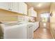 Well-lit laundry room with ample storage, modern appliances, and a window for natural light at 9658 W Golddust Dr, Queen Creek, AZ 85144