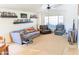 Cozy living room featuring a vaulted ceiling, neutral carpet, and ample natural light at 11424 S Obispo Dr, Goodyear, AZ 85338