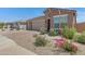 Inviting home with a three-car garage, beautiful landscaping, and vibrant flowering bushes at 1221 E Jahns Dr, Casa Grande, AZ 85122