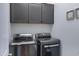 Contemporary laundry room showcasing sleek, modern washer and dryer units with coordinating upper cabinets at 1221 E Jahns Dr, Casa Grande, AZ 85122