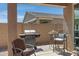 View of a covered patio with a BBQ grill, seating, and a view of the neighbor's roof at 1221 E Jahns Dr, Casa Grande, AZ 85122