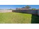 Spacious backyard features a well-maintained lawn and tall block wall, offering privacy and space for outdoor activities at 12801 W Sweetwater Ave, El Mirage, AZ 85335