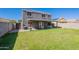 Expansive backyard with green grass and a covered patio, as seen from the yard at 12801 W Sweetwater Ave, El Mirage, AZ 85335