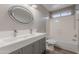 Modern bathroom featuring a double sink vanity, an oval mirror, and a shower-over-tub setup at 12801 W Sweetwater Ave, El Mirage, AZ 85335