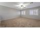 Spacious bedroom featuring neutral walls, carpet, a ceiling fan, and natural light from the windows at 12801 W Sweetwater Ave, El Mirage, AZ 85335