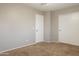 Bedroom with neutral walls, carpet, a ceiling fan, and two white doors at 12801 W Sweetwater Ave, El Mirage, AZ 85335