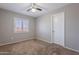 Bedroom with neutral walls, carpet, a ceiling fan, window with blinds, and a white door at 12801 W Sweetwater Ave, El Mirage, AZ 85335