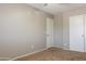 Bedroom with neutral walls, carpet, a ceiling fan, and two white doors at 12801 W Sweetwater Ave, El Mirage, AZ 85335