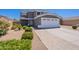 Charming two-story home with landscaped front yard, paved driveway, and a two-car garage at 12801 W Sweetwater Ave, El Mirage, AZ 85335