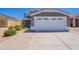 View of house facade featuring the two-car garage and desert landscaping at 12801 W Sweetwater Ave, El Mirage, AZ 85335