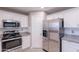 Contemporary kitchen featuring stainless steel appliances, granite countertops, and white cabinets at 12801 W Sweetwater Ave, El Mirage, AZ 85335