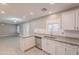Bright kitchen featuring white cabinetry, stainless steel appliances, granite countertops, and an open layout at 12801 W Sweetwater Ave, El Mirage, AZ 85335